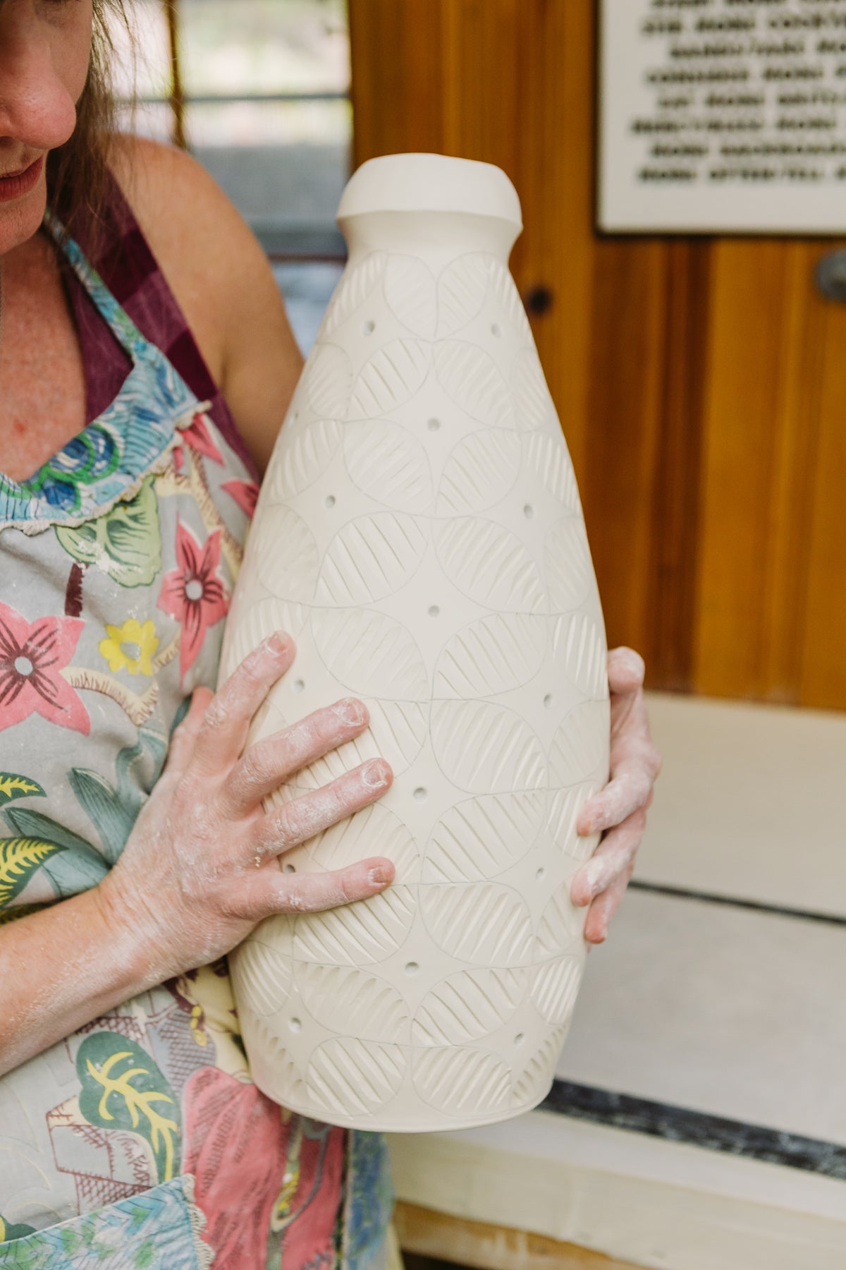 Julie Wiggins holds an in progress porcelain vase 